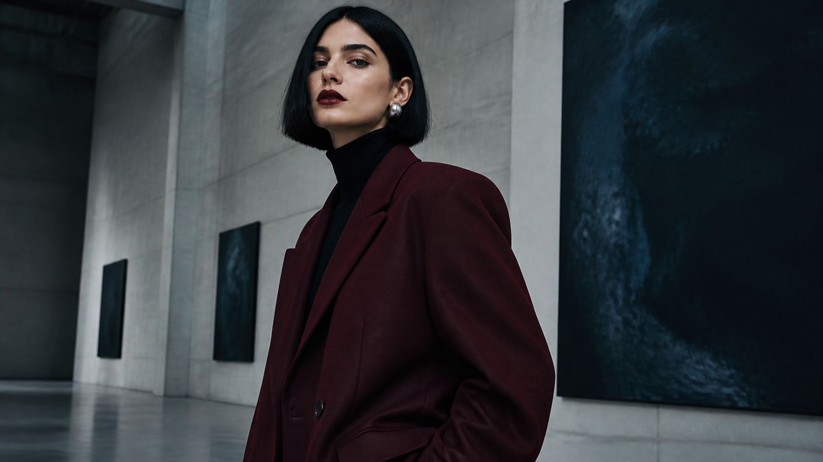 Young woman with a sleek black bob in a burgundy blazer and black turtleneck, wearing Dark Winter colors